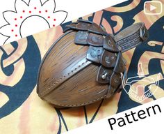 a brown leather object sitting on top of a colorful table cloth next to a flower