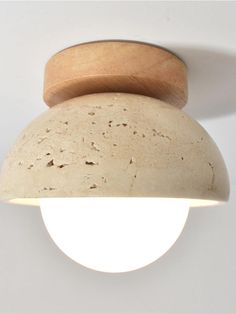 a light that is on the side of a wall with a wooden object attached to it