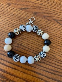 This is a wristlet keychain with animal print and solid black, white and natural beads. White Beaded Keychains For Everyday Use, Casual White Keychains With Key Leash, Casual White Keychain With Key Leash, White Round Beads Keychains For Everyday Use, Phone Charms, Fort Wayne, Wristlet Keychain, Black Leopard, Phone Charm