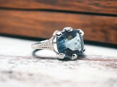 We are loving the rich blue color of this stunning aquamarine gemstone!! She is paired with a beautiful white gold engraved vintage setting. Ring Details Material: 18K White Gold Era: Art Deco 1920 - 1940 Head Width: 11.8mm Head Height: 6.5mm Weight: 3.5 Grams Finger Size: 6 Sizable Upon Request Accented by the following gemstone 1 - 10.7mm X 9.8mm X 6.5mm Cushion Brilliant Cut Aquamarine Gemstone; Vivid Blue Color; Known Weight: 4.78 Carats Item: 768TMV8-9T Vintage Setting, Antique Jewelry Rings, Aquamarine Ring, Gold Engraving, Aquamarine Rings, Aquamarine Gemstone, Rings Statement, Vintage Watches, Aquamarine