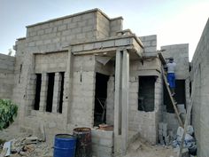 a man standing on a ladder in front of a building under construction with bricks and cement