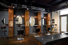 the interior of a hair salon with chairs and mirrors