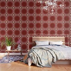 a bedroom with red wallpaper and a chandelier hanging from the ceiling, next to a bed