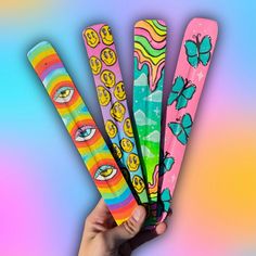 four colorful toothbrushes with different designs on them in front of a multi - colored background