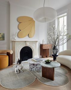 a living room filled with furniture and a dog sitting on the floor next to a fire place