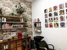 a hair salon with brick wall and shelves full of products on the wall next to it