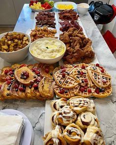 a table topped with waffles, fruit and other desserts next to bowls of dip