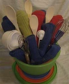 a green cup filled with lots of different colored kitchen utensils and whisks