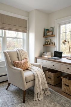 a white chair sitting in front of a window next to a desk with a laptop computer on it