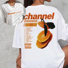 the back of a woman's white shirt with an orange print on it, which reads channel orange