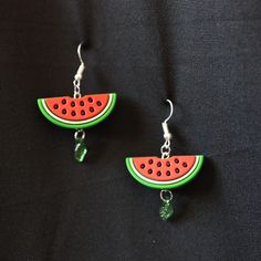 two slices of watermelon are hanging from earrings