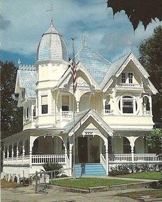 a large white house with an american flag on it's front porch and two story