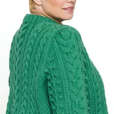 a woman with blonde hair wearing a green sweater