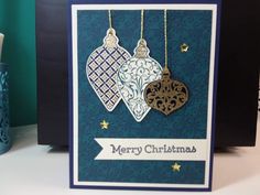 a christmas card with two ornaments hanging from it