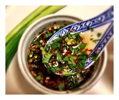 a bowl filled with vegetables and sauce on top of a table