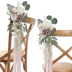 two wooden chairs with flowers and greenery on the back one has a pink ribbon