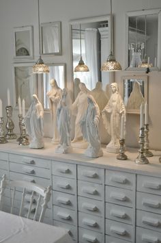 there are many statues on the dressers in this room and one is holding a candle