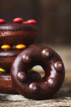 chocolate donuts with m & m written on them sitting next to eachother