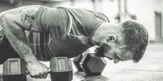 a man doing push ups with two dumbbells in his hand and looking down at the ground