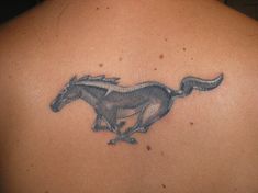 a horse tattoo on the back of a woman's shoulder