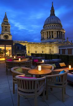 an outdoor seating area with candles lit up in front of the dome and clock tower