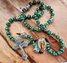 This listing isfor a hand knotted rosary, featuring beautiful dark green glass beads, Silver large ornate Our Father beads, and a splendid image of Our Lady of Guadelupe centerpiece. The centerpiece is water proofed and has a delicate filigree design around Our Holy Mother's image. The image is authentic of the Miraculous tilma of Mexico, and holds many blessings as for her devotees. Tve crucifix is in antique silver metal and has a plenary indulgence attached to the veneration of this crucifix. Our Lady Guadalupe, Knotted Rosary, Lady Guadalupe, Bead Rosary, Mother Images, Our Father, Green Beads, Gorgeous Glass, Filigree Design