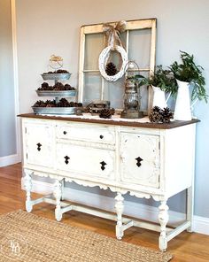 a white dresser with pine cones on top