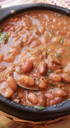 a skillet filled with beans on top of a wooden table