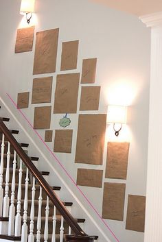 a staircase with several pieces of paper taped to the wall and some lights on either side