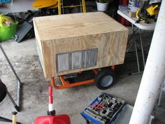 a small wooden box sitting on top of a cart next to other boxes and tools