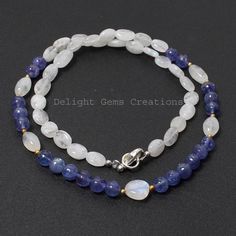 Product Details : ITEM : TANZANITE AND RAINBOW MOONSTONE BEADED NECKLACEItem Code : DGC2580Gemstone Name :  SMOOTH ROUND/ TUMBLEChain Style : BEADEDBeads Shape : SMOOTH ROUND/ SMOOTH OVAL TUMBLEBeads Size : 6.5/8.5x7-11x6.5 mm ApproxLength : 18.5 INCH WITH LOBSTER CLASPWeight : 130 Cts. ApproxCustomization : **Available**Please Feel Free To Contact If You Have Any Query. Handmade Oval Beads Gemstones For Gift, Handmade Oval Bead Gemstones For Gift, Oval Gemstone Beads Necklace Perfect For Gifts, Oval Natural Stones For Gifts, Handmade Oval Bead Gemstones For Jewelry Making, White Oval Gemstone Beads Necklaces, Blue Oval Necklaces With Faceted Beads, Blue Moonstone Round Bead Necklaces, Blue Oval Gemstone Beads