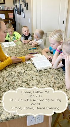 a group of children sitting at a kitchen table with an open book in front of them