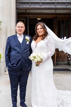 a bride and groom pose for a photo outside the entrance to their wedding ceremony at st paul's cathedral