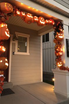 a house decorated for halloween with pumpkins and lights