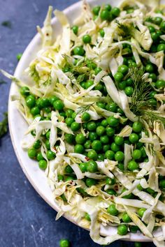 a white plate topped with peas and shredded cabbage