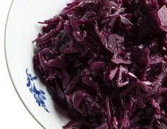 a white bowl filled with red cabbage on top of a table