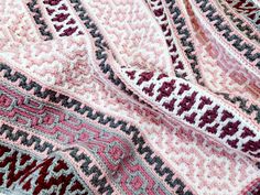 a close up view of a crocheted blanket with red, white and blue colors