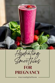 a smoothie in a glass with strawberries and raspberries on the side