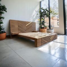 a bed that is sitting in the middle of a room with potted plants next to it