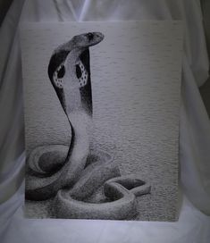 a black and white drawing of a snake with its mouth open on a sheet of paper