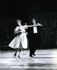 two people are dancing on the floor in an old fashion dress and tuxedo