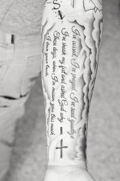 a person with a cross on their arm and some writing on the back of his arm