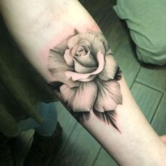 a black and white rose tattoo on the arm