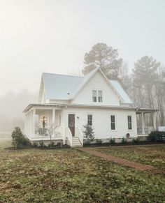 a white house in the middle of a foggy field