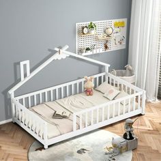 a white baby crib sitting on top of a wooden floor next to a window