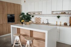 a kitchen with two stools in front of the counter and an island that has flowers on it