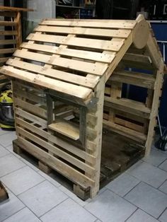 a dog house made out of wooden pallets