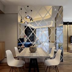 a dining room table with white chairs and a mirror on the wall in front of it