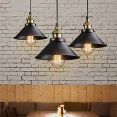 three lights hanging over a table in a restaurant