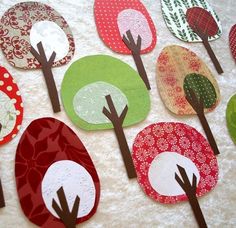 paper trees are arranged on a table with red, green, and white circles around them